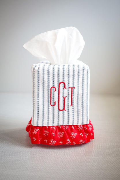 blue ticking stripe tissue box cover with red ruffle detailing and red custom embroidered monogram on white background