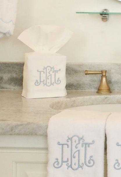 Personalized white tissue box cover with custom ornate three-letter monogram in blue embroidery, elegant bathroom accent piece.