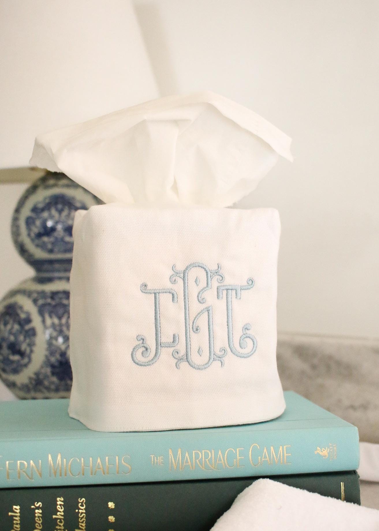 White cotton tissue box cover with embroidered triple-letter monogram in blue thread, matching fingertip towels for bathroom décor.