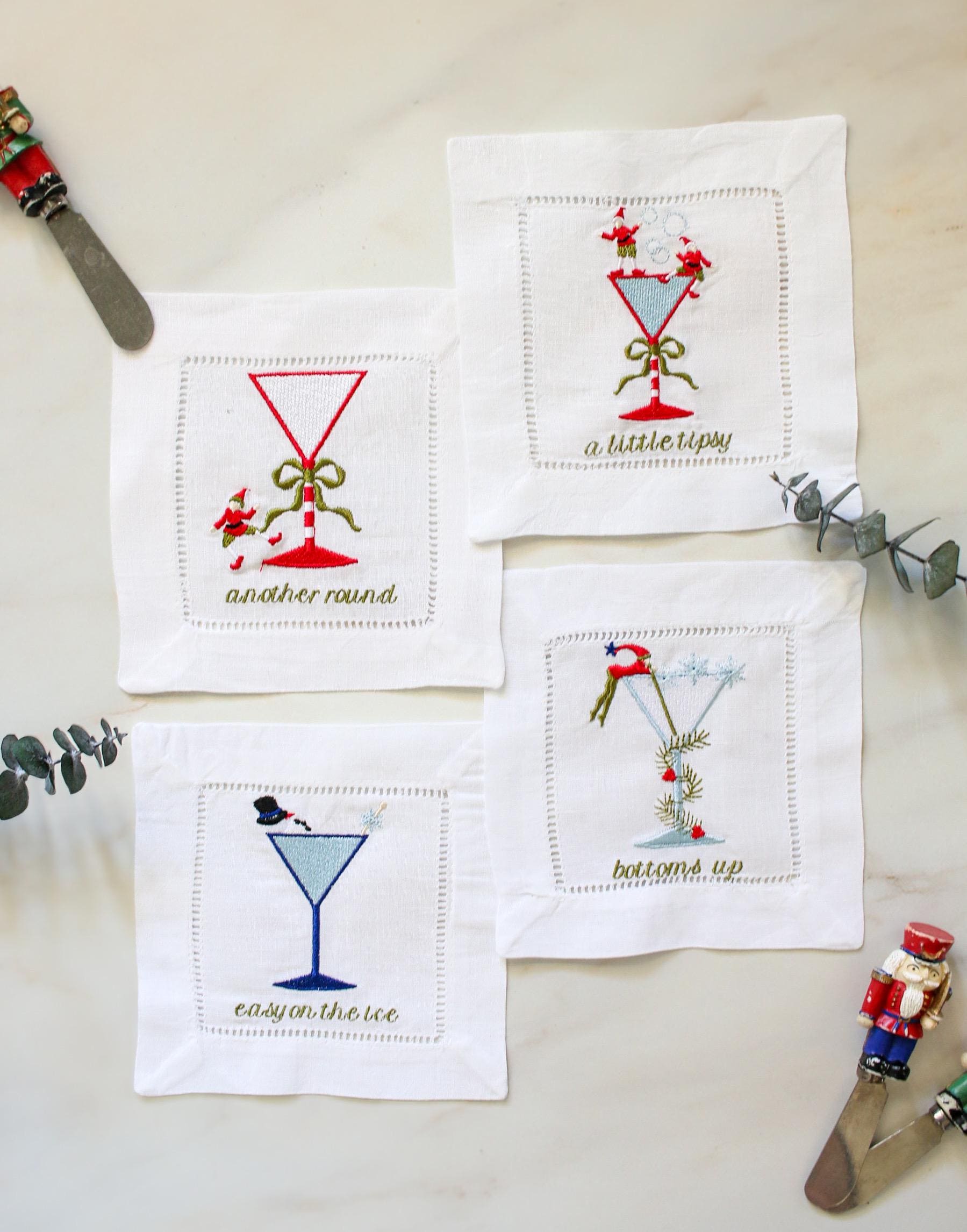 Set of 4 embroidered linen cocktail napkins – whimsical Christmas martini glass designs, perfect for holiday entertaining.